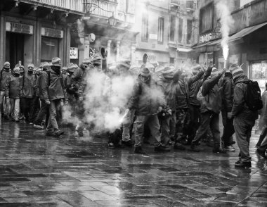 Venice, Italy, march 4th 1015, anti capitalist demonstrators blocking access to the rialto bridge wearing masks and flares with smoke