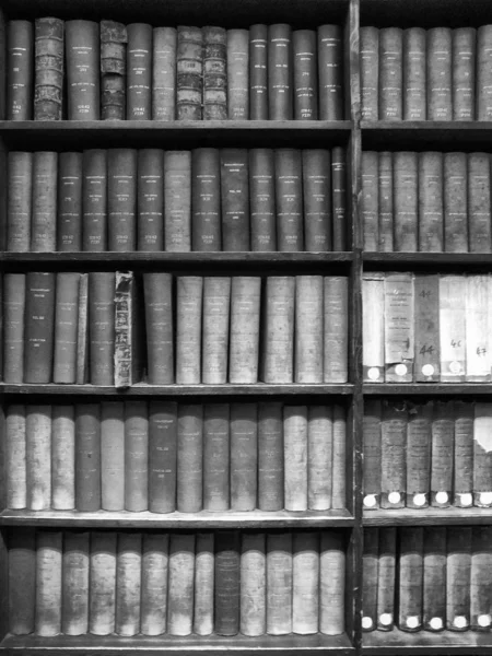 旧参考书堆放在木制架子上 — 图库照片