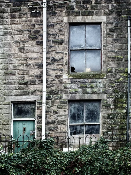 Verlassenes Haus mit kaputten Fenstern und Efeu — Stockfoto