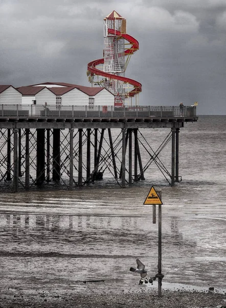 Pier and helter skelter in herne bay kent in cloudy dark summer — Stock Photo, Image