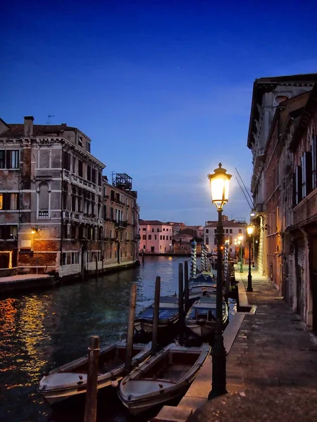 Venice at night with lamplight reflected in the water boats and — Stock Photo, Image