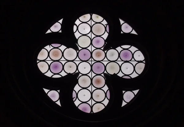 Janela de vidro manchado roxo redondo com design de cruz ou flor — Fotografia de Stock