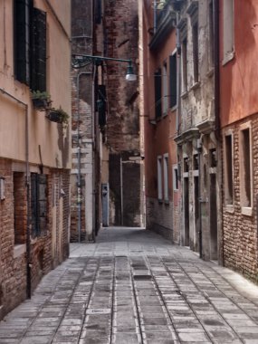 Venedik 'te kırmızı boyanmış eski binalarla dolu bir sokak 