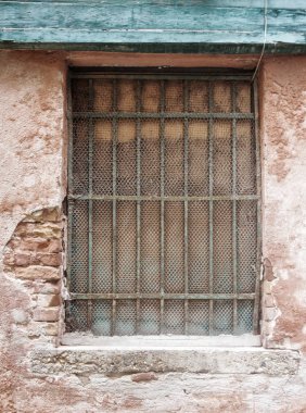 bir metal çubuklar ve çelik örgü ile eski bir binada pencere