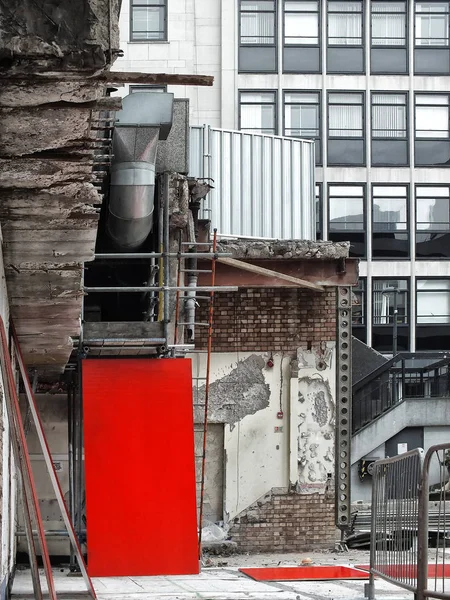 Demolizione e sdoganamento di un vecchio edificio in un contesto urbano con scala e assi rosse con scale e uffici sullo sfondo — Foto Stock