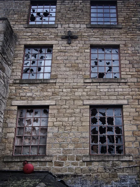 Ventanas rotas en un viejo edificio de piedra destrozado abandonado vacío — Foto de Stock