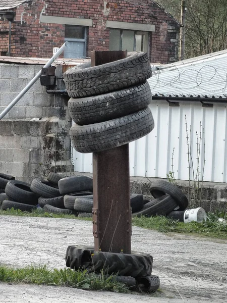 Vieux pneus empilés sur une poutre métallique dans un dépotoir — Photo