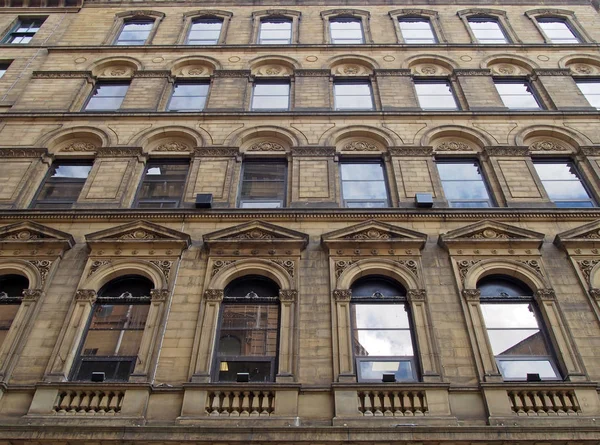 La facciata di un grande edificio commerciale in pietra del XIX secolo nella piccola zona germanica di Bradford West Yorkshire con ornate finestre in stile neoclassico — Foto Stock