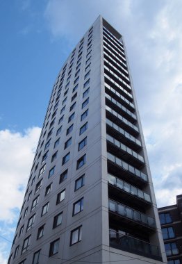 Clarence House, 218 feet yüksekliğinde modern bir daire ve Leeds rıhtımında mavi bulutlu bir gökyüzüne karşı perakende binası.