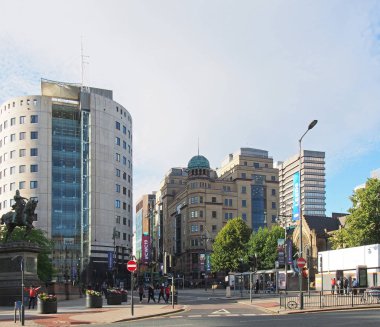 Leeds, Batı Yorkshire 'da şehir meydanı. Şehir binalarının ve anıtların önünden geçen insanlar var.