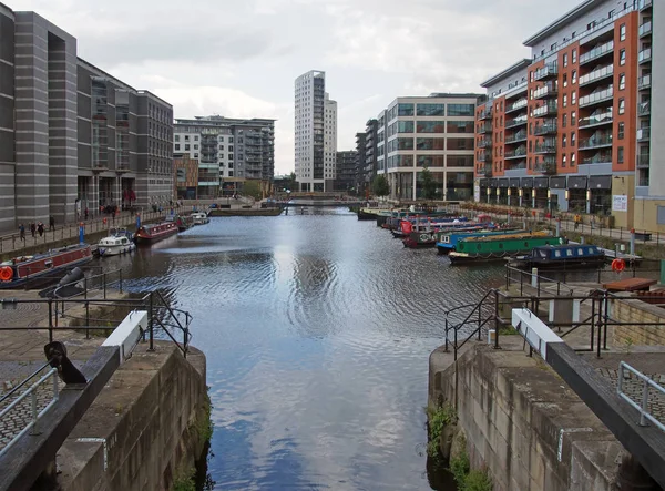 A view of clarence dock in leeds with moored barges and people walking around the surrounding buildings — Stock Photo, Image