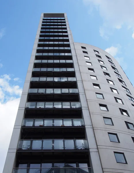 clarence house a 218 foot tall modern apartment and retail building in the leeds dock area against a blue cloudy sky