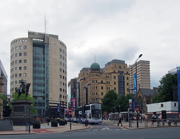 Autobuses y peatones cruzando la calle en la plaza de la ciudad sanguijuelas con altos edificios de oficinas de fila del parque — Foto de Stock