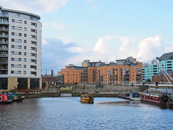 Una vista de las puertas de bloqueo en el muelle de leeds con un taxi de agua amarilla y casas flotantes amarradas a lo largo del muelle — Foto de Stock