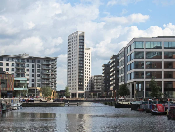 Utsikt över Leeds docka med klartecken hus omgiven av modern lägenhet utveckling och barer med förtöjda husbåtar och blå molnig himmel — Stockfoto