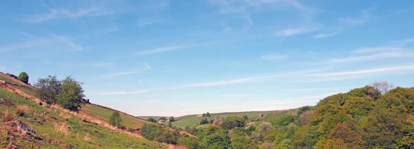 En lång panoramautsikt över västra Yorkshire landsbygd med fält och hedar ovanför skogen i hardcastle crags med en blå solljus molnhimmel — Stockfoto