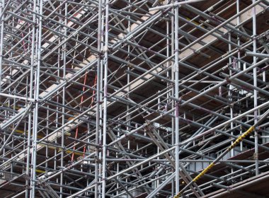 İnşaat alanındaki çalışma platformlarını destekleyen metal yapı direkleri.