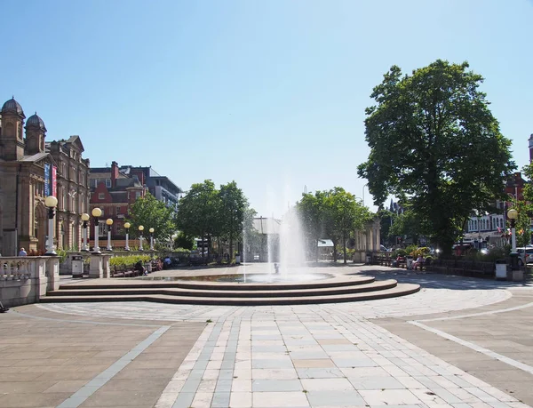La plaza pública y la fuente en la calle lord en southport con gente sentada en bancos en un día de verano soleado — Foto de Stock