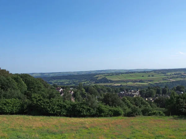 Uma vista panorâmica do campo oeste de yorkshire com a aldeia de Warley cercada por bosques e terras agrícolas com peninos colinas à distância — Fotografia de Stock