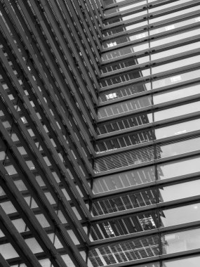 Gri cam pencerelere yansıyan geometrik şekilleri ve binaları olan tam çerçeveli modern ofis mimarisi