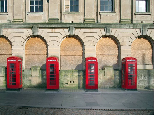 英国黑池地区一座废弃的旧邮局大楼外 一排由四个传统的英国红色电话亭组成的电话线路 — 图库照片