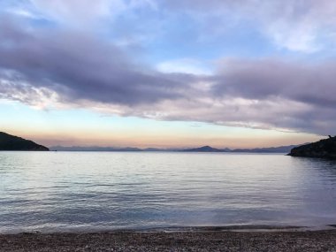 Deniz üzerinde güzel bulutlu bir manzara, gün batımı görüntüsü