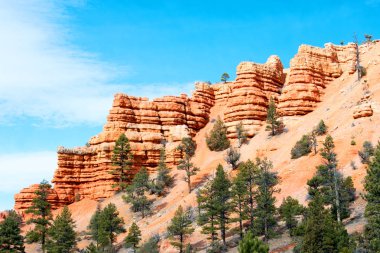 Mavi bulutlu gökyüzü altında yeşil bitkiler ile güzel kumlu dağlar manzara