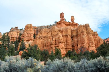Mavi bulutlu gökyüzü altında yeşil bitkiler ile güzel kumlu dağlar manzara