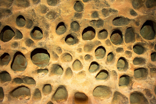 Сыроподобная каменная стена с отверстиями
