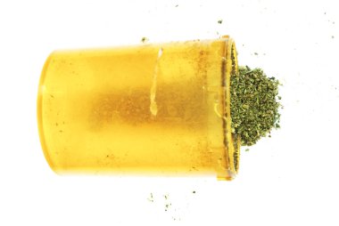 Beyaz arka planda marihuana ve sarı plastik şişe nin yakından görünümü