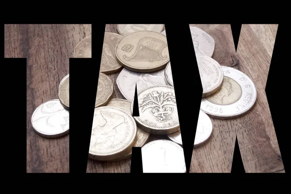 木製の背景にコインと黒の背景に税のレタリング — ストック写真