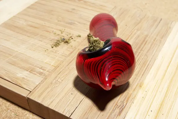 Marihuana Und Rote Pfeife Auf Holztisch — Stockfoto