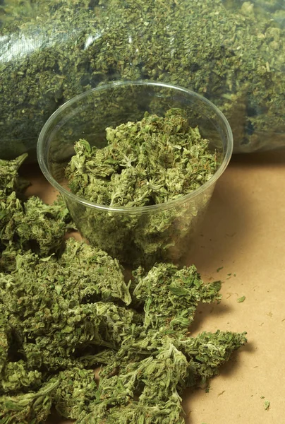 干大麻和塑料杯的特写视图 吸毒概念 医用大麻概念 — 图库照片