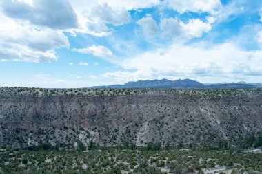Bulutlu gökyüzü altında yeşil bitkiler ile güzel kumlu dağlar manzara