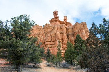 Bulutlu gökyüzü altında yeşil bitkiler ile güzel kumlu dağlar manzara