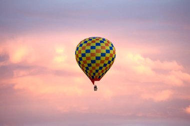 Parlak damalı hava ballon pembe alacakaranlık gökyüzünde uçan