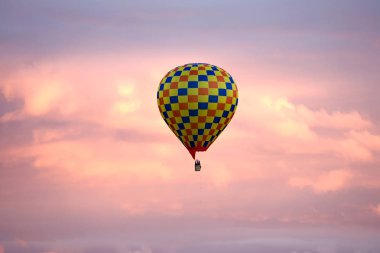Parlak damalı hava ballon pembe alacakaranlık gökyüzünde uçan