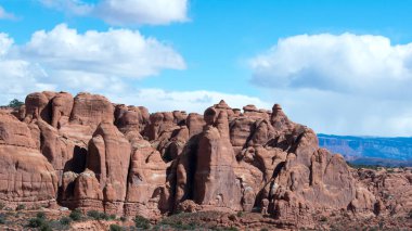 Bulutlu gökyüzü altında yeşil bitkiler ile güzel kumlu dağlar manzara