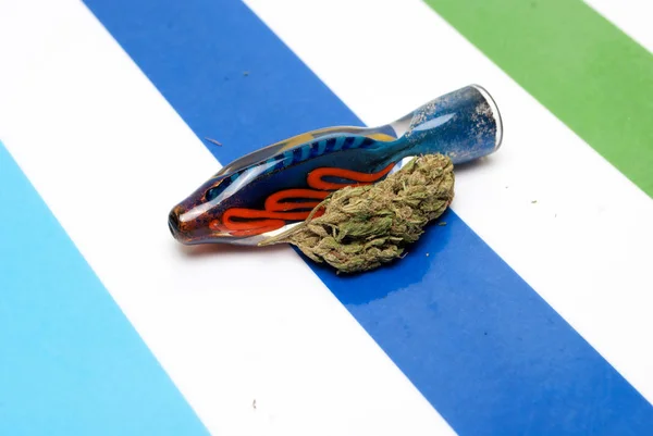 カラフルなストライプの背景に乾燥マリファナと青い喫煙パイプ 薬物中毒の概念 医療用マリファナの概念 — ストック写真