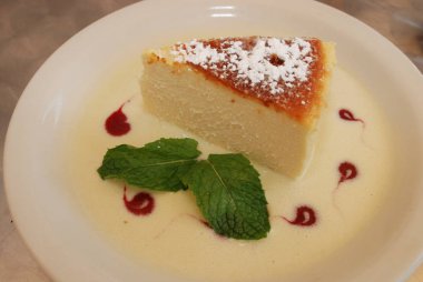 Beyaz tabakta nane yaprakları ile Cheesecake