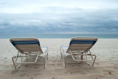 Deniz manzarası arka plan ile sahilde iki şezlong