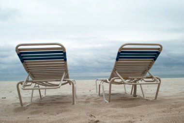 Deniz manzarası arka plan ile sahilde iki şezlong