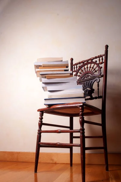 Stack of books on vintage wooden chair