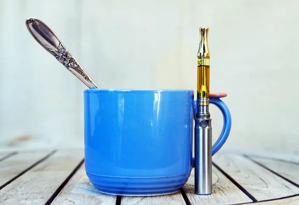 Bir fincan kahve ve bir şişe Cbd yağı.