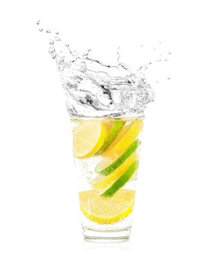 Bardak su üzerinde beyaz izole limon ve kireç dilimleri. Su sıçramalarına yapım düşen meyve. 