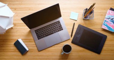 Yaratıcı profesyonel grafik tasarımcı Illustrator çalışma alanı. İşyeri hava üstten görünüm. Modern ahşap masa Danışma dizüstü bilgisayar, Grafik Tablet, Stylus, kahve kupa, not defteri, lamba, Sketchbook, kalem