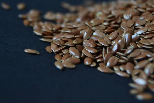 flax seeds, linen seeds on black background. healthy food. raw. vegan.