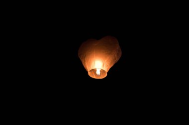 Karanlık gökyüzünde kayan beyaz fener.