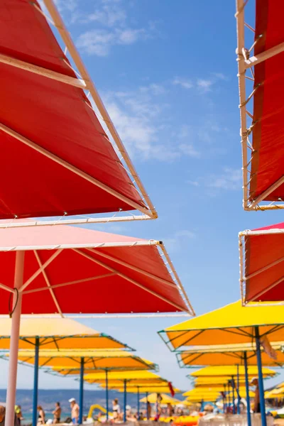 Människor på stranden och parasoller. — Stockfoto