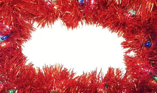 Işıklı beyaz zemin üzerine kırmızı Noel Tinsel Garland. Mutlu bayramlar ve Sezon selamlar çerçeve.